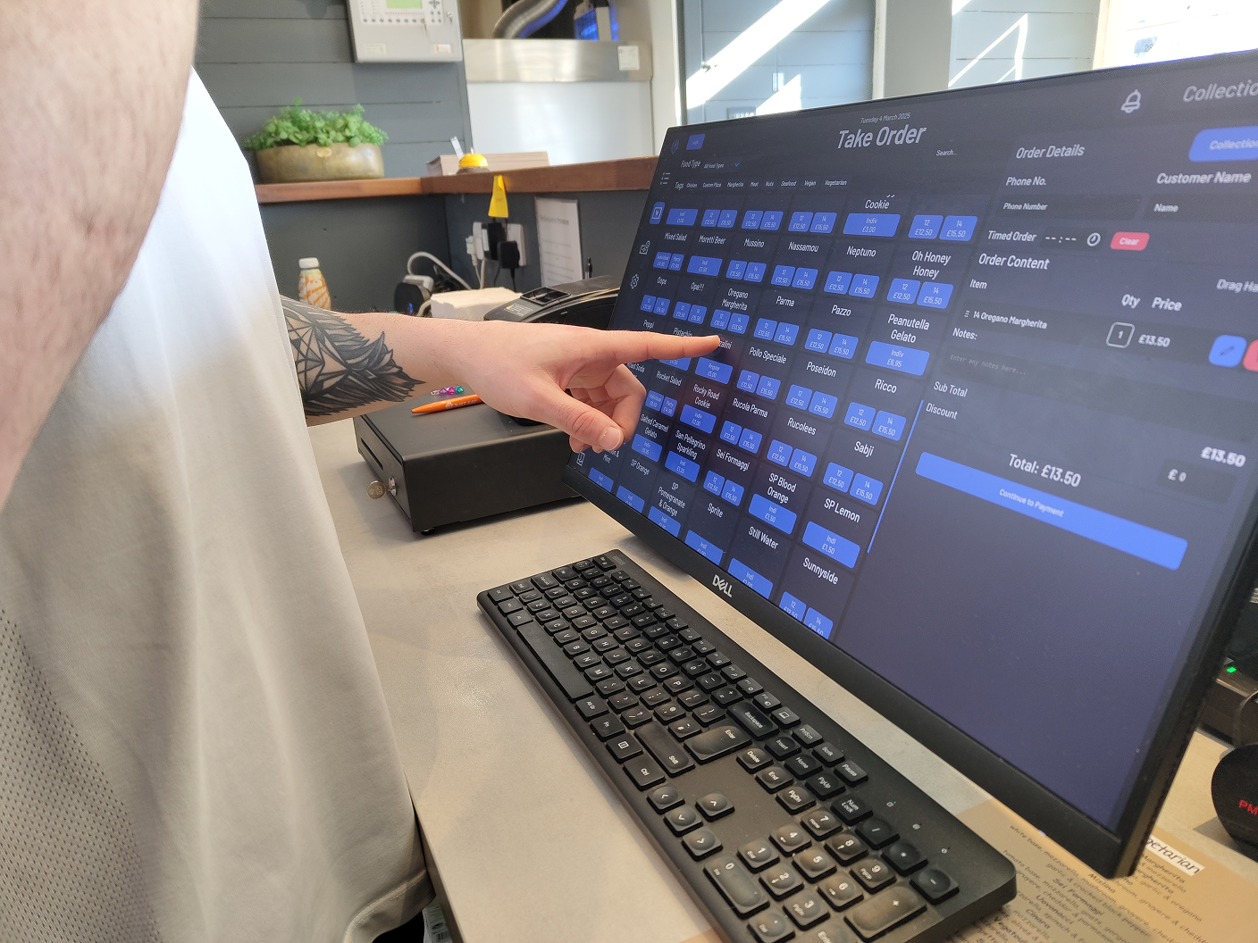 A cashier using the Posperity POS system on a touchscreen terminal in a restaurant